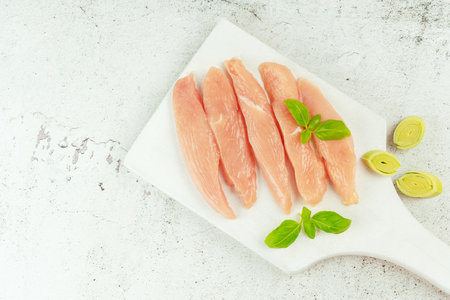 Chicken breast Fillets.Close up.Raw chicken meat.Raw fresh chicken fillet on a gray background with fresh herbs.Copy space.Food for retail.Ogranic food,healthy eating.Food concept.Top view.の写真素材