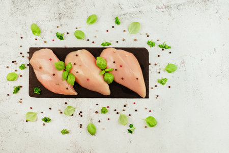 Chicken breast Fillets.Close up.Raw chicken meat.Raw fresh chicken fillet on a gray background with fresh herbs.Copy space.Food for retail.Ogranic food,healthy eating.Food concept.Top view.の写真素材