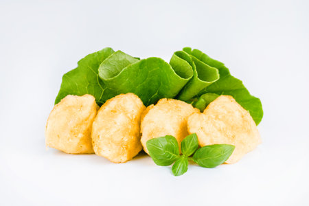 Breaded chicken nuggets.Breaded Chicken Inner Fillet with green lettuce leaves on a White Background.Chicken Breaded Raw Meat,Fillet.Fast homemade food at home. Chicken breaded schnitzels.Fast cookingの写真素材