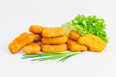Breaded chicken nuggets.Breaded Chicken Inner Fillet with green lettuce leaves on a White Background.Chicken Breaded Raw Meat,Fillet.Fast homemade food at home. Chicken breaded schnitzels.Fast cookingの写真素材