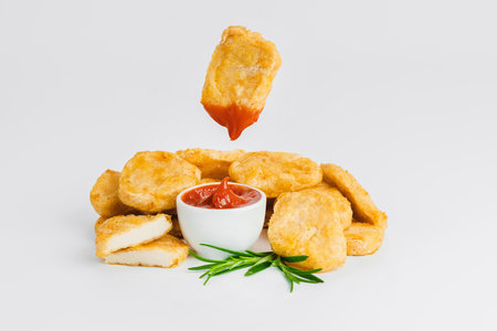 Fast food.Levitation, breaded chicken nuggets, semi-finished product with fresh herbs on a white background. Quick cooking at home. Copy space.の写真素材