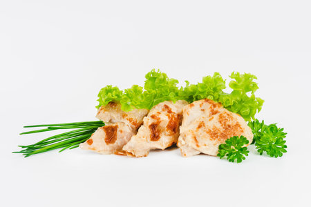 Chicken fillets fried until half cooked, semi-finished product with fresh herbs on a white background. Fast cooking.Fast homemade food.Fast food. Quick cooking at home. Copy space.の写真素材