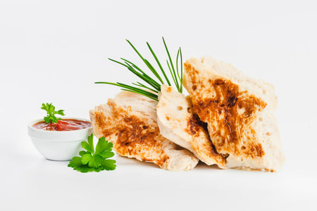 Chicken fillets fried until half cooked, semi-finished product with fresh herbs on a white background. Fast cooking.Fast homemade food.Fast food. Quick cooking at home. Copy space.の写真素材