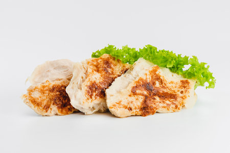 Chicken fillets fried until half cooked, semi-finished product with fresh herbs on a white background. Fast cooking.Fast homemade food.Fast food. Quick cooking at home. Copy space.の写真素材