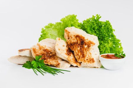 Chicken fillets fried until half cooked, semi-finished product with fresh herbs on a white background. Fast cooking.Fast homemade food.Fast food. Quick cooking at home. Copy space.の写真素材