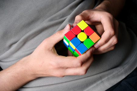 Hands solving a colorful puzzle cube illustrating mental challengeの写真素材