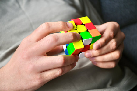 Hands solving a colorful puzzle cube illustrating mental challengeの写真素材