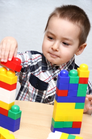 Child builds a tower with plastic blocksの写真素材