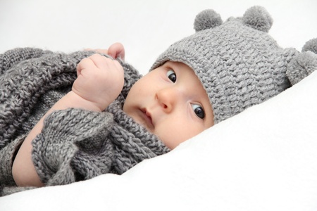 Beautiful baby in gray knitted hat の写真素材