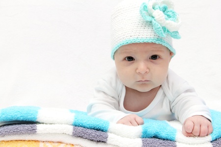 Baby with a knitted white hat with a flowerの写真素材