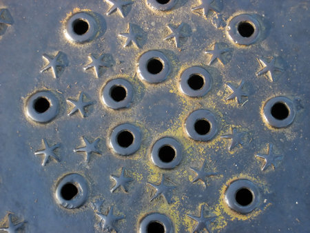 Detail of a historic metal manhole cover with a stars motif in the Presido park in San Francisco, CA