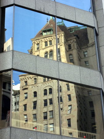 Reflection of an older skyscraper on the surface of a newer mirrored skyscraper in San Francisco's...