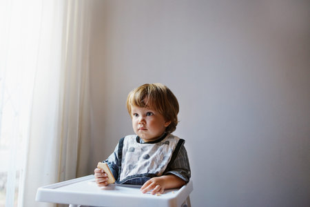 Shot of an adorable little boy sitting in his high chair
