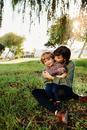 Shot of a single mother spending some time at the park with her sonの写真素材