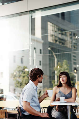 Shot of a young couple on a coffee date at a sidewalk cafeの写真素材