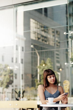 Shot of an attractive young woman at a coffee shopの写真素材