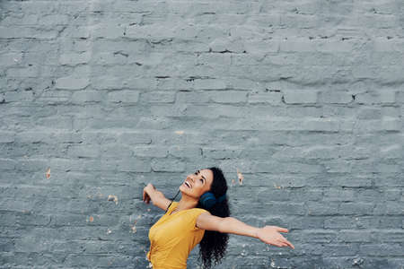 Cropped shot of an attractive young woman wearing headphones and dancing while listening to music outdoorsの写真素材
