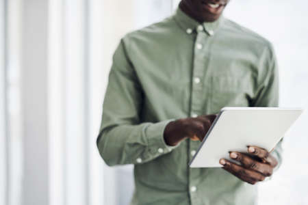 Closeup shot of an unrecognisable businessman using a digital tablet in an officeの写真素材