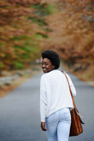 A young woman walking outside on an autumn dayの写真素材