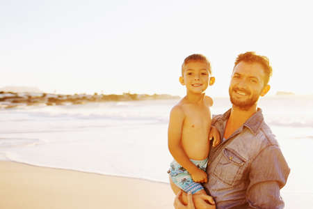 Portrait of a father bonding with his little son at the beachの写真素材