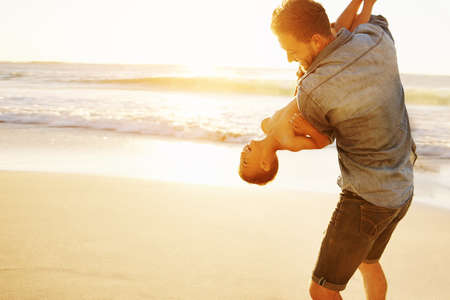 Shot of a father bonding with his little son at the beachの写真素材