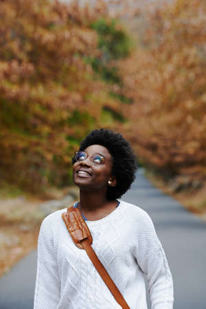 A young woman walking outside on an autumn dayの写真素材