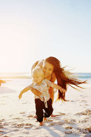 Shot of a mother bonding with her little son at the beachの写真素材