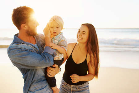 Shot of a happy family having fun at the beachの写真素材