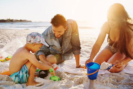Shot of a family building sandcastles together at the beach
