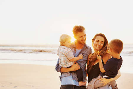 Shot of a happy young family having a fun day at the beachの写真素材