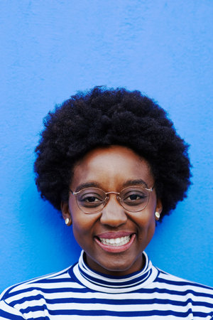 Studio shot of a young woman posing against a blue background
