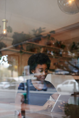 Shot of a young woman using a digital tablet in a cafe