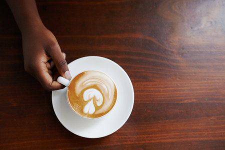 Cropped shot of a woman holding a cup of coffeeの写真素材