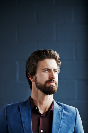 Cropped shot of a young corporate businessman standing against a dark background