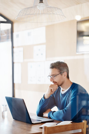 Cropped shot of a handsome designer working on his laptop in the office