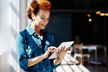 Cropped shot of a young businesswoman working on a digital tablet in an office