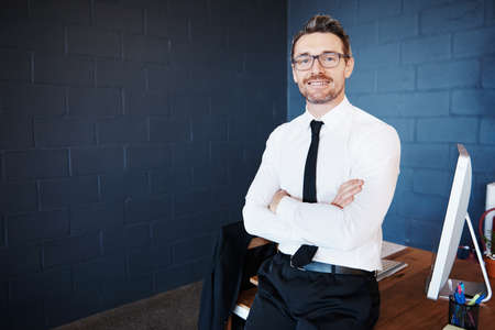 Portrait of a mature corporate businessman standing in an officeの写真素材