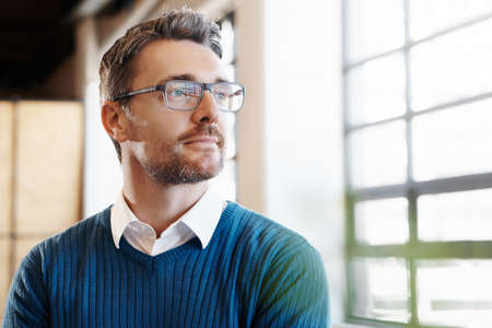 Shot of a mature businessman looking thoughtful while standing in his officeの写真素材