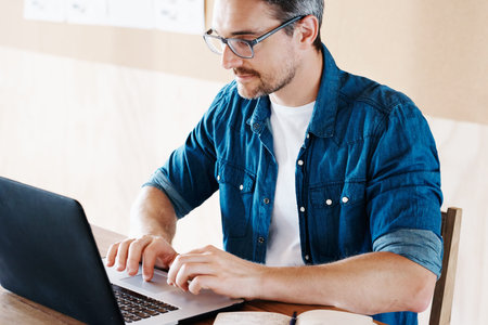 Cropped shot of a handsome designer working on his laptop in the office