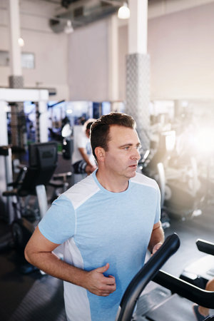 Shot of a mature man exercising on a treadmill in a gym