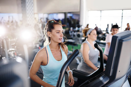 Shot of a young woman exercising on a treadmill in a gymの写真素材