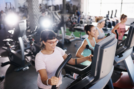 Shot of a young woman exercising on a treadmill in a gymの写真素材
