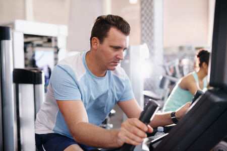 Shot of a mature man working out on an exercise bike in a gymの写真素材