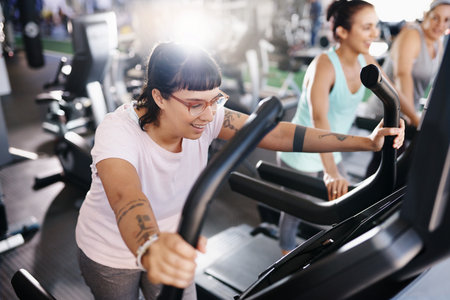 Shot of a young woman exercising on a treadmill in a gymの写真素材