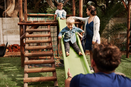 Shot of a beautiful young family of four playing together at the park