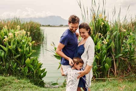 Shot of a beautiful young family of three spending some time together at the parkの写真素材