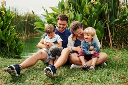 Full length shot of a beautiful young family of four spending some time together outdoorsの写真素材