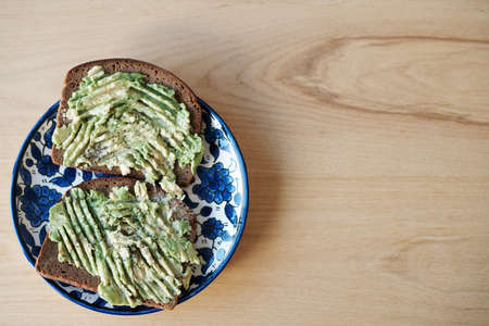 Still life shot of avocado on toasted bread served on a plateの写真素材