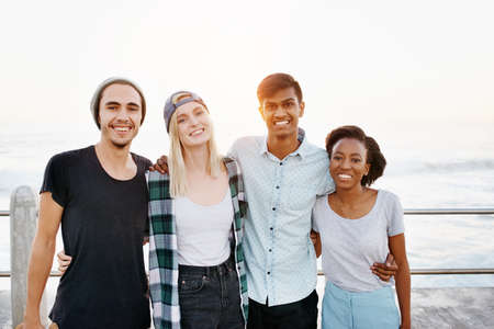 Cropped portrait of a group of young friends standing on the promenadeの写真素材