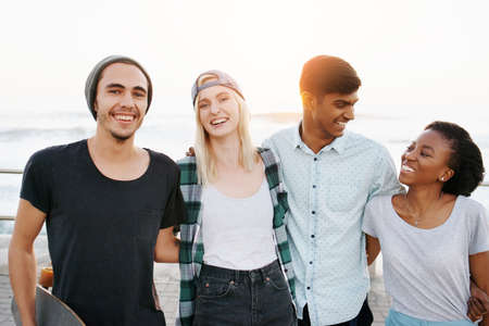 Cropped portrait of a group of young friends standing on the promenadeの写真素材